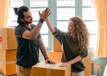 People high-fiving and moving into a rental with housing affordability