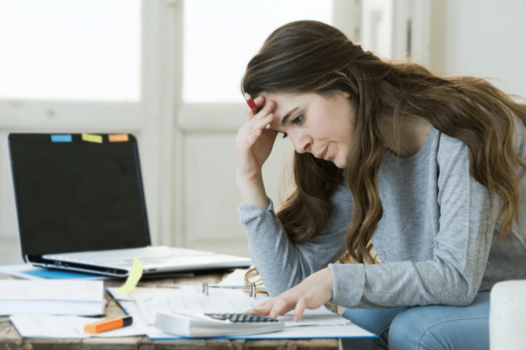 person looking stressed while reviewing bills