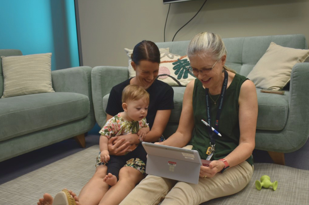 caregiver, baby and practitioner reviewing video of baby playing
