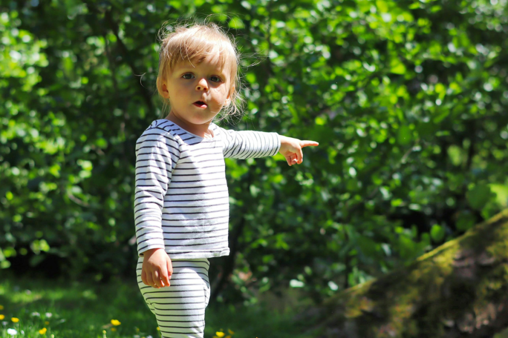 Young child outside pointing and asking questions