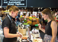 Woman tasting fresh produce while browsing stalls at Adelaide Central Market