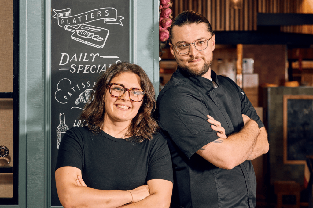 Les Deux Coqs owners Alexis and Audrey standing outside their stall at Adelaide Central Market