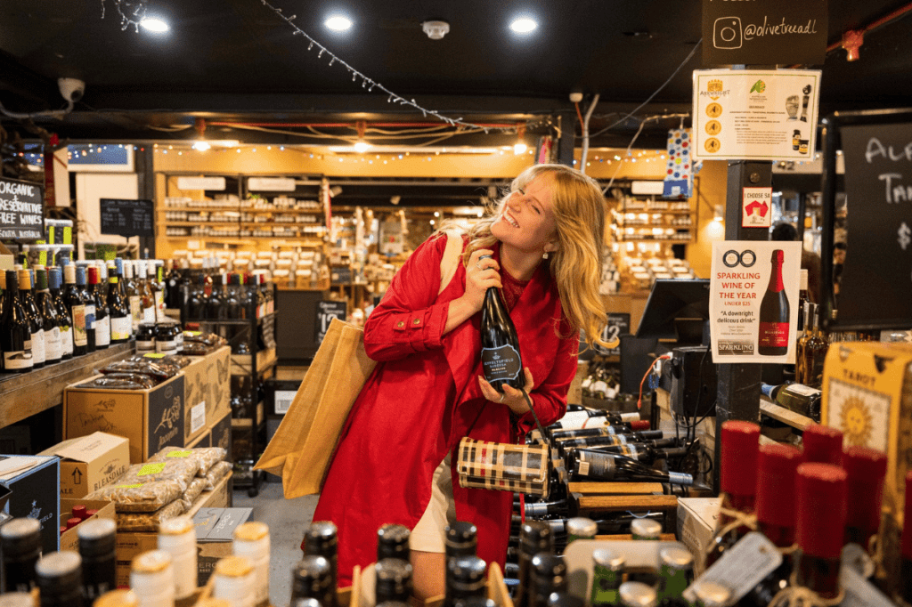 Customer holding a bottle of wine inside The Olive Tree at Adelaide Central Market