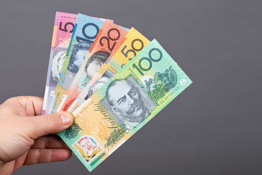 Hand holding cash to represent wages and take-home pay.