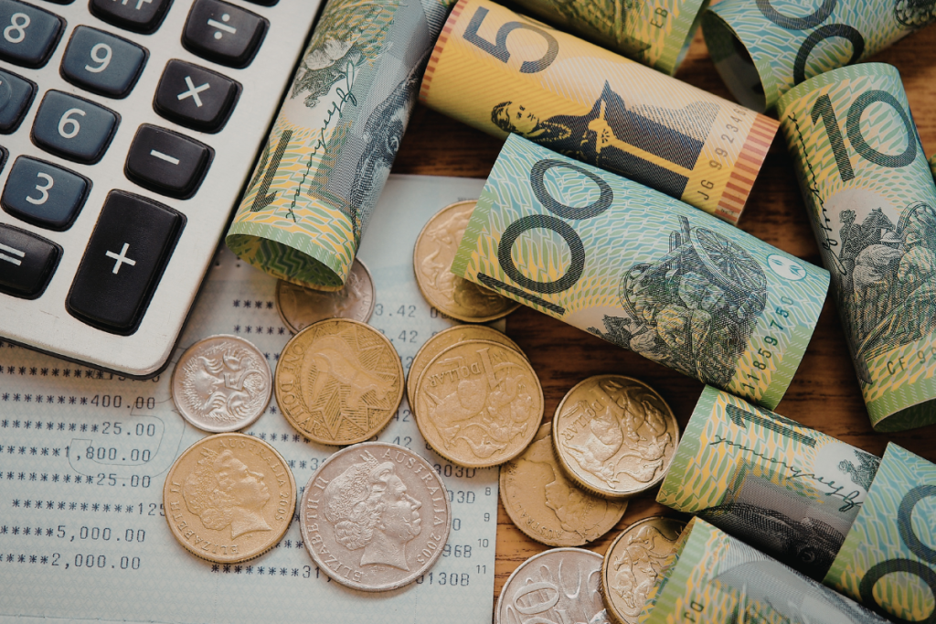 Cash, a calculator and financial paperwork representing pay and budgeting.