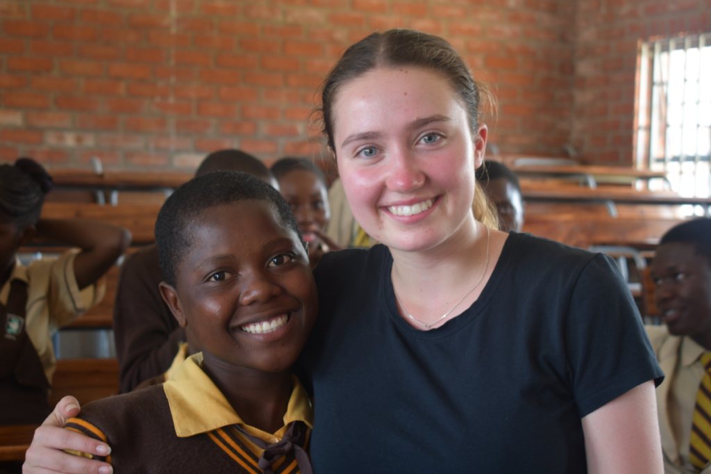 Lucy Stevens standing with student during trip to Zimbabwe and South Africa