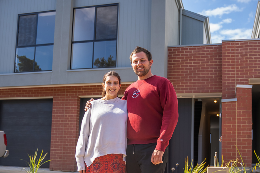 First home buyers in front of their new home.