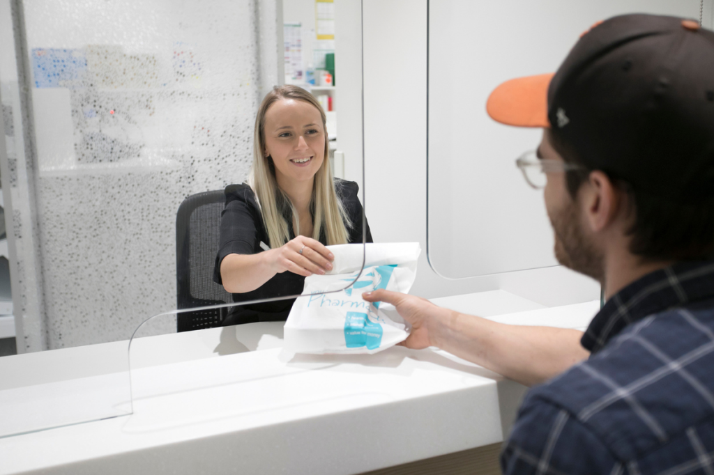 Pharmacist at 24-hour pharmacy in Adelaide dispencing script to customer.