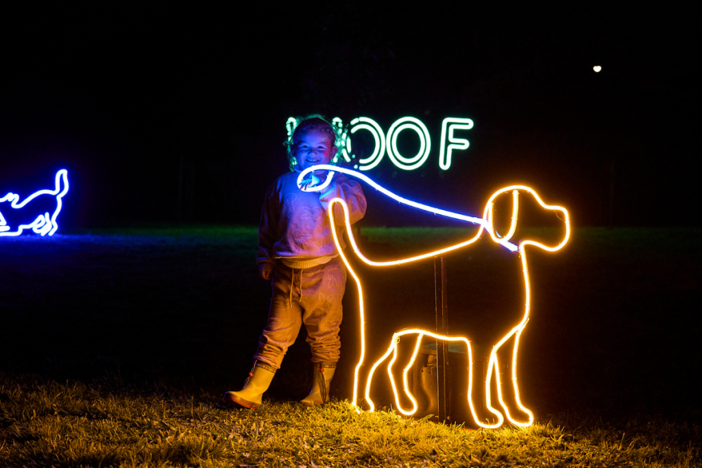 Child with neon dog at Illuminate Adelaide's Neon Dog Park